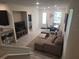 Bright, open-concept living room with modern furniture, tiled floors, and natural light from the door and windows at 129 Boydfield Ln, Davenport, FL 33837