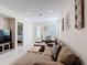 Spacious living room featuring stylish decor, tile flooring, and seamless flow to the dining area at 129 Boydfield Ln, Davenport, FL 33837