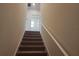 Carpeted staircase featuring white walls and trim leads to the upper level of the home at 129 Boydfield Ln, Davenport, FL 33837