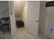 An under-stairs storage area featuring a dark table on tiled flooring is accessible through a white paneled door at 129 Boydfield Ln, Davenport, FL 33837