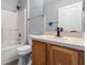 Full bathroom with wood vanity, white toilet, showerhead over tub and tile flooring at 135 Inconnu Ct, Kissimmee, FL 34759