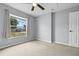 This simple, carpeted bedroom has a large window with curtains, and neutral walls at 135 Inconnu Ct, Kissimmee, FL 34759