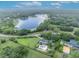 Aerial view of lakeside property features a fenced yard, mature trees, pristine lake, and refreshing backyard pool at 1415 Brumley Rd, Chuluota, FL 32766