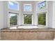 Bright bathroom featuring a soaking tub surrounded by multiple windows offering scenic outdoor views at 1415 Brumley Rd, Chuluota, FL 32766