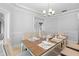 Spacious dining area with a large table set for a meal, chandelier, and crown molding at 1415 Brumley Rd, Chuluota, FL 32766