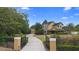Exterior view of home and long driveway, framed by mature trees and front gate at 1415 Brumley Rd, Chuluota, FL 32766