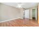 Cozy bedroom with hardwood floors, a ceiling fan, and a convenient en-suite bathroom entrance at 1422 Russell Ave, Orlando, FL 32806