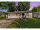 Charming single-story home featuring a well-maintained lawn and a classic design, nestled amongst mature trees at 1422 Russell Ave, Orlando, FL 32806