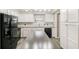 Modern kitchen with sleek black appliances, white cabinetry, and a central island for food preparation and dining at 1422 Russell Ave, Orlando, FL 32806