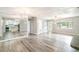 Bright, open-concept living area with hardwood floors and a view into the kitchen and front door at 1422 Russell Ave, Orlando, FL 32806