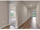 Inviting hallway showcasing hardwood flooring and a glimpse into a carpeted room with natural light at 14322 Sw 28Th Ave, Ocala, FL 34473