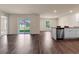 Open-concept living room featuring wood floors, sliding glass doors, and a modern kitchen with stainless steel appliances at 14322 Sw 28Th Ave, Ocala, FL 34473