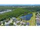 An elevated view showcasing homes near a tranquil pond and sprawling green spaces at 14566 Quail Trail Cir, Orlando, FL 32837