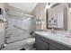 Bathroom features a shower-over-tub with glass doors, gray vanity with granite countertop, and a framed mirror at 14566 Quail Trail Cir, Orlando, FL 32837