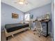 Bedroom with blue walls, wood floor, a bed, a desk with monitors and office chair, and natural light at 14566 Quail Trail Cir, Orlando, FL 32837