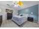 Bedroom with modern decor, a queen sized bed, wood floor, and a blue accent wall at 14566 Quail Trail Cir, Orlando, FL 32837