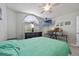 Bright bedroom featuring an arched window, a ceiling fan, mounted TV and ample room for sleep and study at 14566 Quail Trail Cir, Orlando, FL 32837