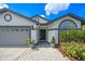 Inviting front entrance with decorative plants, a paved walkway, and a modern door at 14566 Quail Trail Cir, Orlando, FL 32837