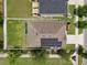 A bird's eye view showcases a well-maintained lawn, solar panels, and the house's roof design at 1565 Diamond Loop Dr, Kissimmee, FL 34744