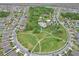 Aerial view featuring a community park with a pool, tennis courts, and ample green space surrounded by homes at 1565 Diamond Loop Dr, Kissimmee, FL 34744