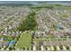 Expansive aerial view of a residential community with mature trees and landscaping near a large pond at 1565 Diamond Loop Dr, Kissimmee, FL 34744