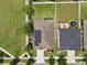 An aerial perspective highlights the house's solar panels, manicured lawn and neighborhood at 1565 Diamond Loop Dr, Kissimmee, FL 34744