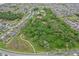 Aerial view of a neighborhood with homes bordering a lush community park, trails, and a pool at 1565 Diamond Loop Dr, Kissimmee, FL 34744