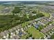 Aerial view featuring homes situated near community amenities like a pool, tennis court, and wooded park at 1565 Diamond Loop Dr, Kissimmee, FL 34744