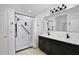 Modern bathroom features a double vanity, a large mirror, a walk-in shower with tile surround and matte black fixtures at 1565 Diamond Loop Dr, Kissimmee, FL 34744