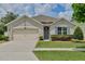 Charming single-story home featuring a well-manicured lawn, gray door, and a two-car garage at 1565 Diamond Loop Dr, Kissimmee, FL 34744
