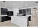 Modern kitchen featuring dark cabinetry, a white quartz island, tile backsplash, and stainless steel appliances at 1565 Diamond Loop Dr, Kissimmee, FL 34744