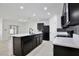 Modern kitchen features dark cabinetry, a white quartz island, tile backsplash, and stainless steel appliances at 1565 Diamond Loop Dr, Kissimmee, FL 34744