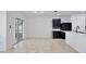 Bright, airy living room with tile flooring, a sliding glass door, and adjacent to a modern, dark kitchen at 1565 Diamond Loop Dr, Kissimmee, FL 34744
