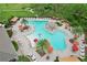 Aerial view of a community pool featuring ample lounge chairs, umbrellas, and a splash area at 1565 Diamond Loop Dr, Kissimmee, FL 34744