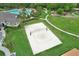 Aerial view of a sand volleyball court surrounded by green lawn and community amenities at 1565 Diamond Loop Dr, Kissimmee, FL 34744