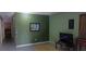 View of an empty room with green walls, tile floors, and a painting at 1612 Eastern Ave, St Cloud, FL 34771