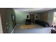 View of an empty living room with bare floors, green walls, and open windows at 1612 Eastern Ave, St Cloud, FL 34771