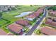 Aerial view of homes with tile roofs, a lake, and a golf course nearby at 1709 Benoit Ter, Davenport, FL 33837