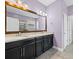 Bathroom vanity with double sinks, granite countertops, large mirror, and modern fixtures at 1709 Benoit Ter, Davenport, FL 33837