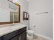 Bathroom with granite countertop vanity and wood-framed mirror, plus a glass enclosed shower at 1709 Benoit Ter, Davenport, FL 33837