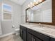 Bathroom with double sink vanity featuring stone countertop and oversized mirror at 1709 Benoit Ter, Davenport, FL 33837