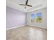 Bedroom showcasing tile flooring, a ceiling fan, and views from two windows at 1709 Benoit Ter, Davenport, FL 33837
