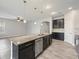 Open kitchen with a large island, dark cabinets, and stainless steel appliances at 1709 Benoit Ter, Davenport, FL 33837