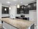 Modern kitchen featuring a large island, stainless steel appliances, and dark cabinets at 1709 Benoit Ter, Davenport, FL 33837