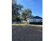 View of a fenced backyard with a small storage shed surrounded by mature trees and green shrubbery at 1732 Sw 6Th St, Ocala, FL 34471