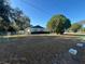 Side view of the house showing the fenced yard, mature tree and surrounding green space at 1732 Sw 6Th St, Ocala, FL 34471