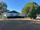 Side view of the house showing the fenced yard, mature tree and surrounding green space at 1732 Sw 6Th St, Ocala, FL 34471
