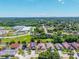 This aerial view shows the location of a property amongst houses, schools, and lots of trees at 1803 Tillstream Dr, Orlando, FL 32818