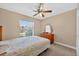 Bedroom with ceiling fan, window overlooking the lawn, and wooden dresser at 1803 Tillstream Dr, Orlando, FL 32818