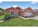 Charming home with an attached two-car garage, a manicured lawn, and attractive landscaping at 1803 Tillstream Dr, Orlando, FL 32818